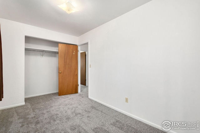 unfurnished bedroom with carpet, baseboards, and a closet