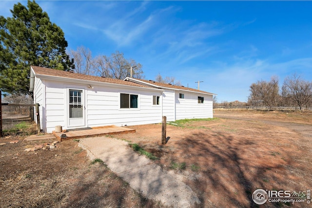 rear view of house featuring fence
