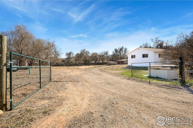 view of dirt / gravel road featuring a gated entry