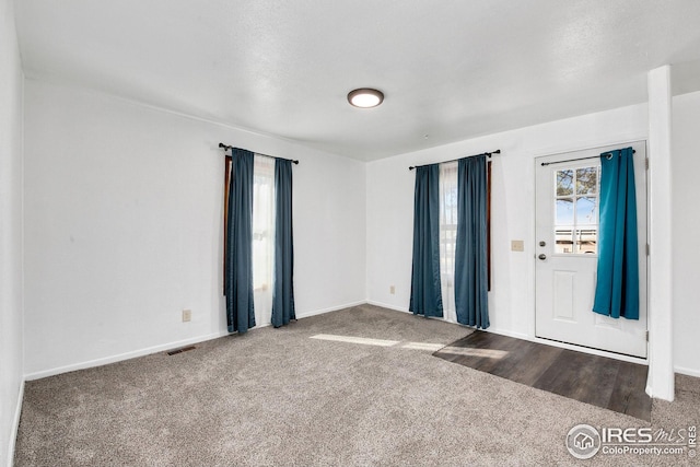 carpeted spare room featuring baseboards