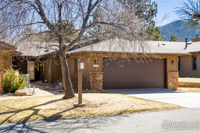 1132 Fairway Club Ln Unit 2, Estes Park, CO 80517 - view of front of home with a garage, driveway, a shingled roof, and a mountain view