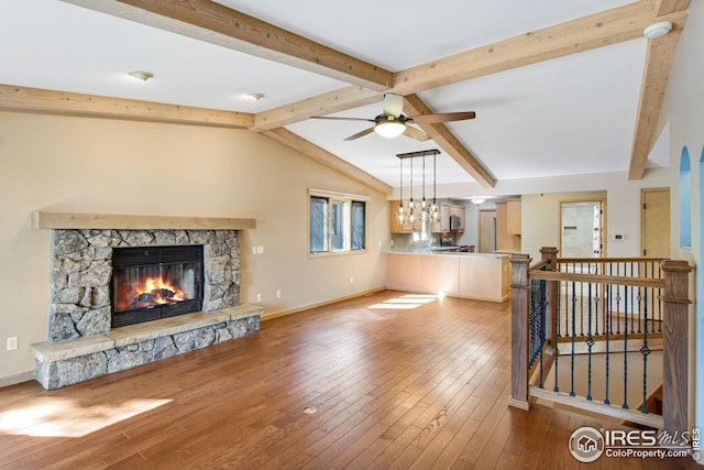 1132 Fairway Club Ln Unit 2, Estes Park, CO 80517 - unfurnished living room with wood-type flooring, a stone fireplace, and baseboards