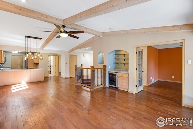 1132 Fairway Club Ln Unit 2, Estes Park, CO 80517 - unfurnished living room with wine cooler, wood finished floors, a ceiling fan, bar, and baseboards