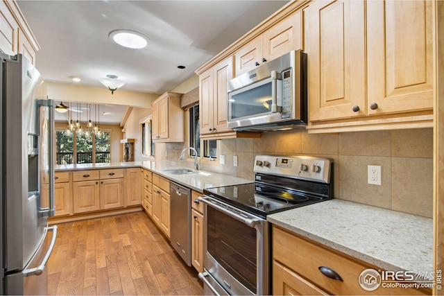 1132 Fairway Club Ln Unit 2, Estes Park, CO 80517 - kitchen featuring appliances with stainless steel finishes, a sink, light brown cabinets, light wood-style flooring, and decorative backsplash