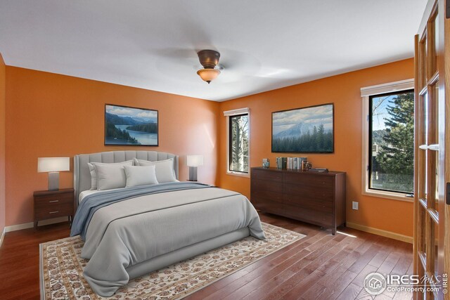1132 Fairway Club Ln Unit 2, Estes Park, CO 80517 - bedroom featuring baseboards, multiple windows, wood-type flooring, and ceiling fan