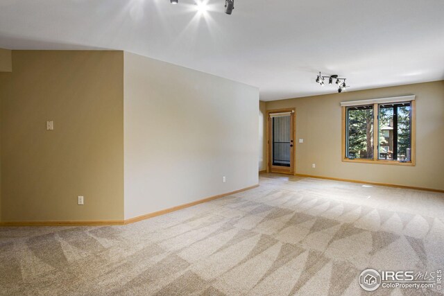1132 Fairway Club Ln Unit 2, Estes Park, CO 80517 - spare room featuring light colored carpet, track lighting, and baseboards