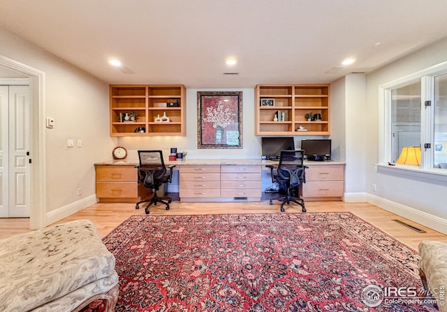 office area with built in study area, light wood-style floors, baseboards, and recessed lighting
