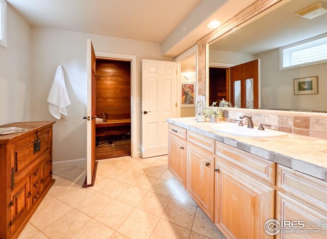 bathroom with vanity, baseboards, and tile patterned floors