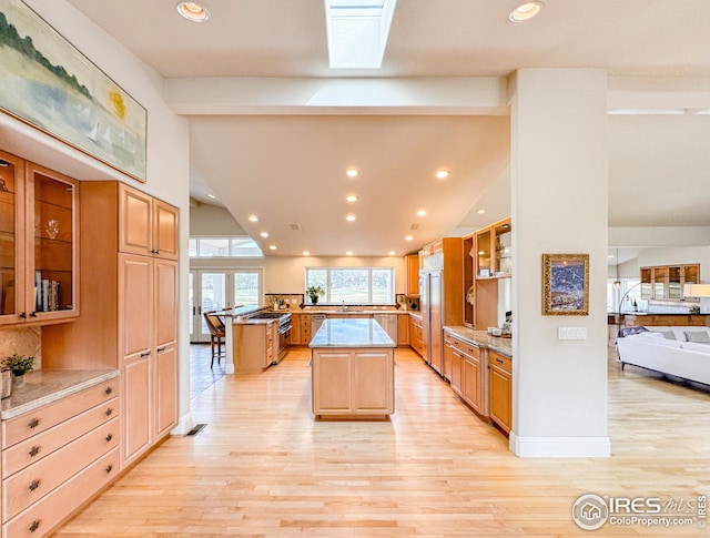 kitchen featuring paneled fridge, light wood finished floors, a center island, a sink, and recessed lighting