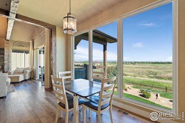 dining area featuring a rural view, a notable chandelier, hardwood / wood-style floors, and visible vents