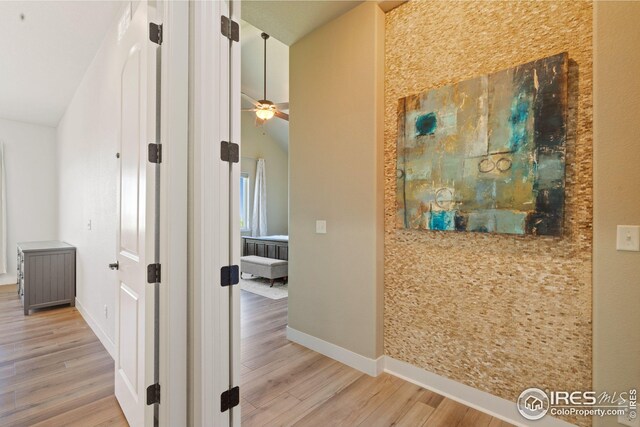 corridor featuring baseboards and wood finished floors