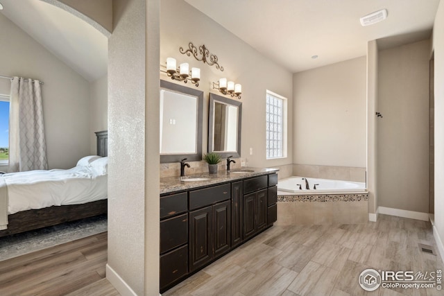 ensuite bathroom featuring a bath, a sink, double vanity, and ensuite bathroom