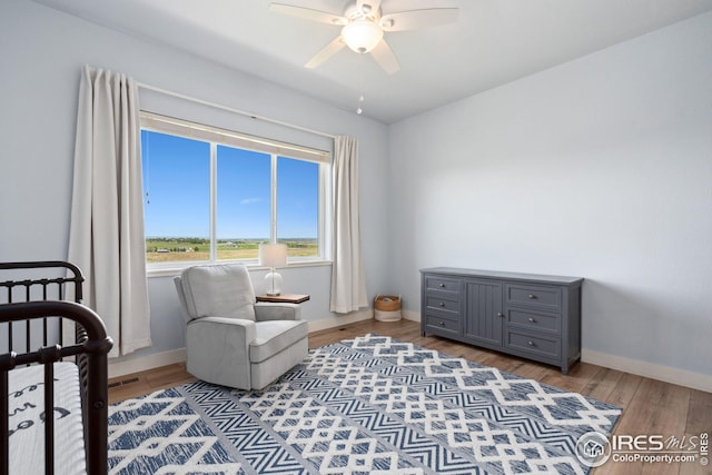 bedroom featuring ceiling fan, baseboards, wood finished floors, and visible vents