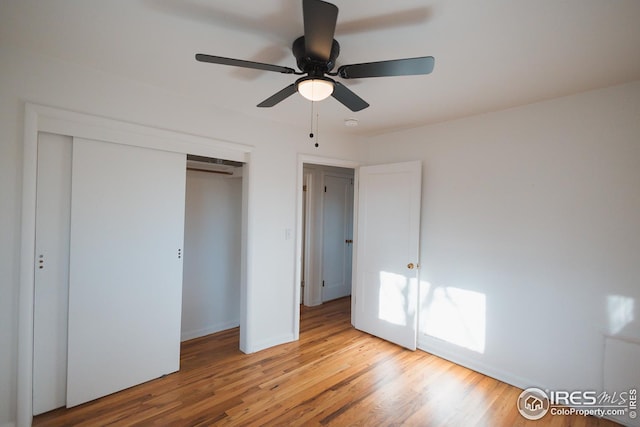 unfurnished bedroom with a closet, baseboards, light wood-style flooring, and a ceiling fan