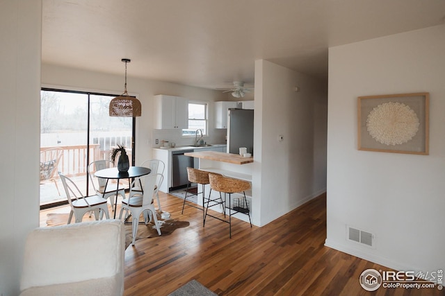kitchen with light countertops, a sink, stainless steel appliances, visible vents, and white cabinets