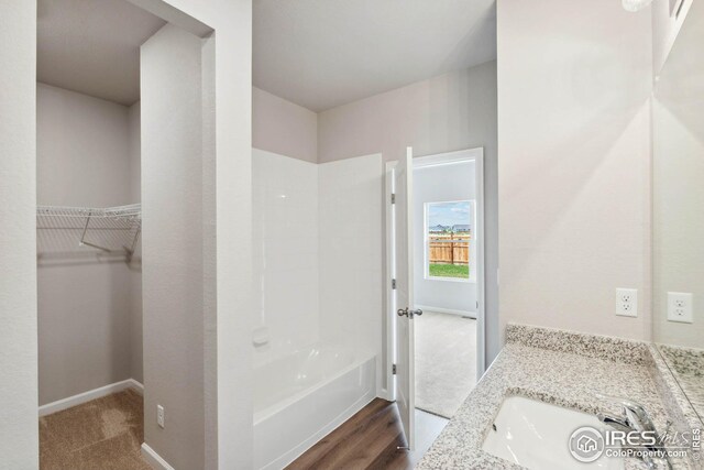 954 Cascade Falls St, Severance, CO 80550 - full bathroom featuring vanity, a spacious closet, and washtub / shower combination