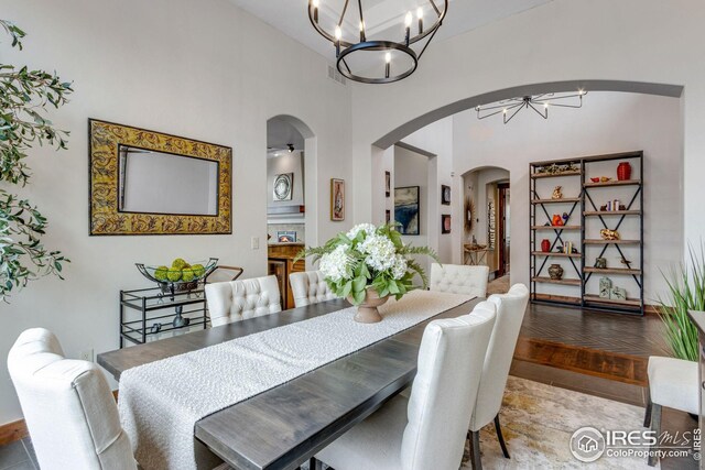 3865 Valley Crest Dr, Timnath, CO 80547 - dining room featuring a notable chandelier, a high ceiling, and arched walkways