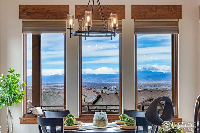 3865 Valley Crest Dr, Timnath, CO 80547 - dining area featuring a healthy amount of sunlight, a mountain view, and an inviting chandelier