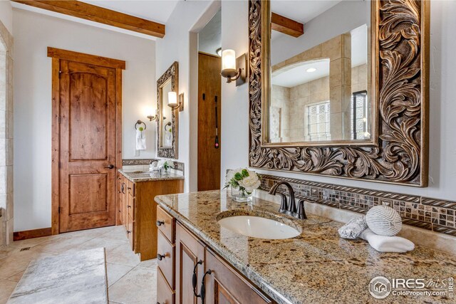 3865 Valley Crest Dr, Timnath, CO 80547 - bathroom featuring tile patterned floors, beam ceiling, a sink, and two vanities