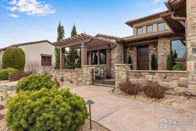 3865 Valley Crest Dr, Timnath, CO 80547 - exterior space with stone siding, a gate, a tiled roof, and stucco siding