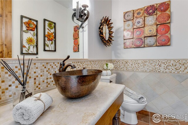 3865 Valley Crest Dr, Timnath, CO 80547 - bathroom with tile walls, toilet, vanity, tile patterned flooring, and wainscoting
