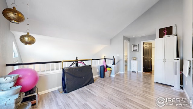 sitting room featuring baseboards, lofted ceiling, an upstairs landing, and wood finished floors
