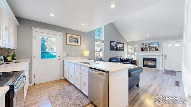 kitchen featuring a sink, a peninsula, stainless steel appliances, visible vents, and white cabinets