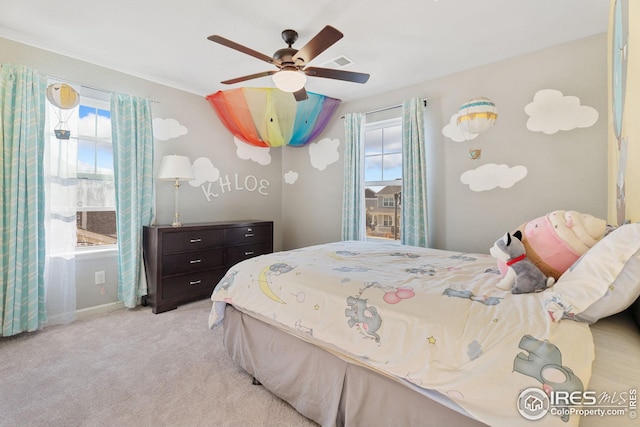 carpeted bedroom featuring ceiling fan, visible vents, and multiple windows