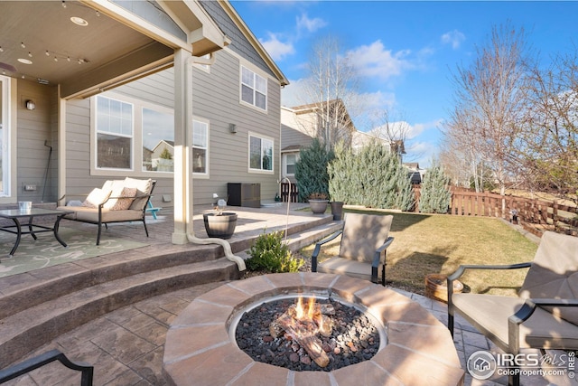 view of patio / terrace with an outdoor living space with a fire pit and fence
