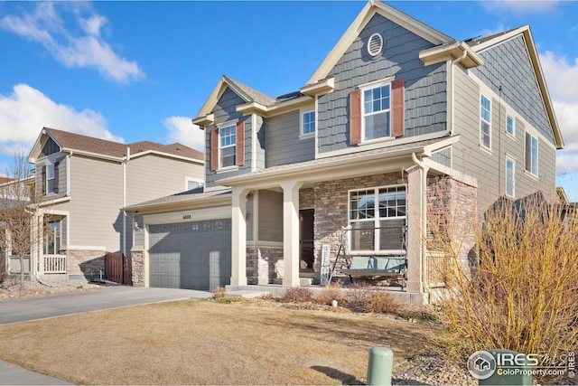 view of front facade featuring covered porch, stone siding, a garage, and aphalt driveway