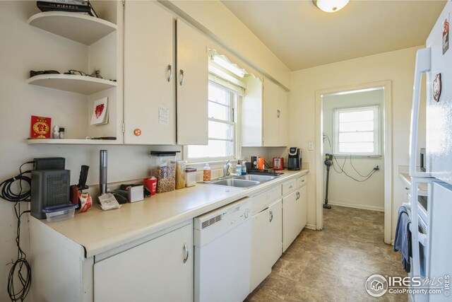 kitchen with white cabinetry, a sink, light countertops, and dishwasher