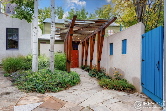 1016 Katy Ln, Longmont, CO 80504 - doorway to property with a pergola, stucco siding, and fence