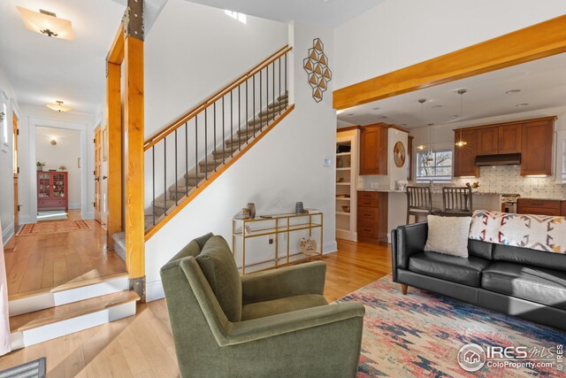 1016 Katy Ln, Longmont, CO 80504 - living room featuring baseboards, stairs, visible vents, and light wood-style floors