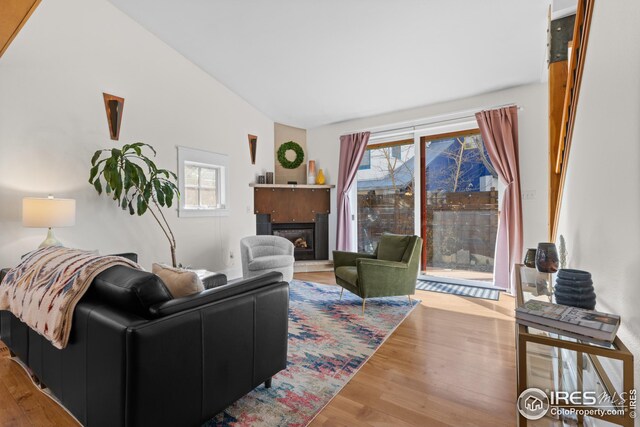 1016 Katy Ln, Longmont, CO 80504 - living room featuring lofted ceiling, a fireplace, and wood finished floors