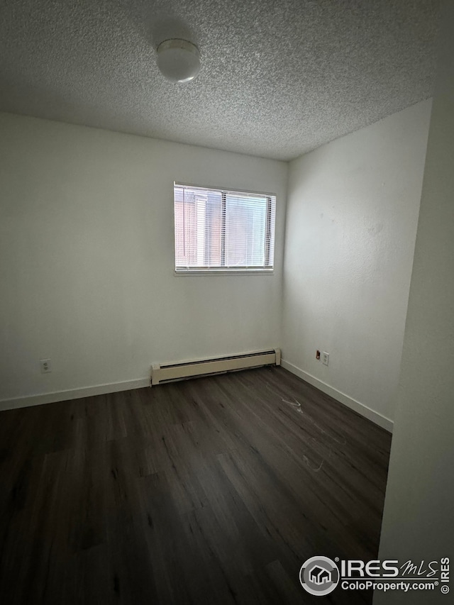 3328 Mcconnell Dr, Laporte, CO 80535 - spare room featuring a textured ceiling, baseboards, a baseboard heating unit, and dark wood finished floors