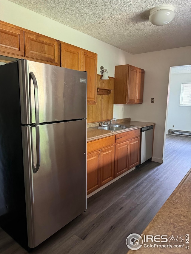 3328 Mcconnell Dr, Laporte, CO 80535 - kitchen with a sink, appliances with stainless steel finishes, brown cabinetry, and dark wood finished floors
