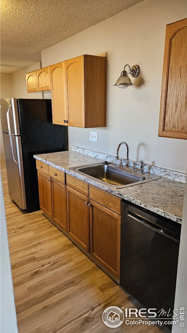 3328 Mcconnell Dr, Laporte, CO 80535 - kitchen with a textured ceiling, dishwasher, a sink, light wood-type flooring, and freestanding refrigerator
