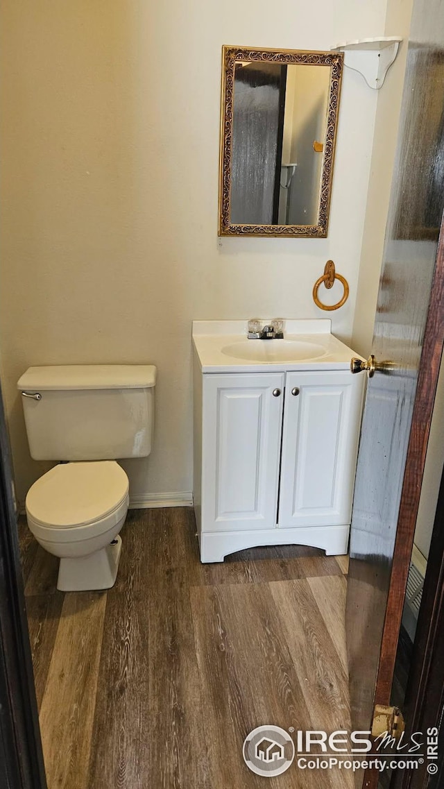 3328 Mcconnell Dr, Laporte, CO 80535 - bathroom featuring baseboards, wood finished floors, toilet, and vanity