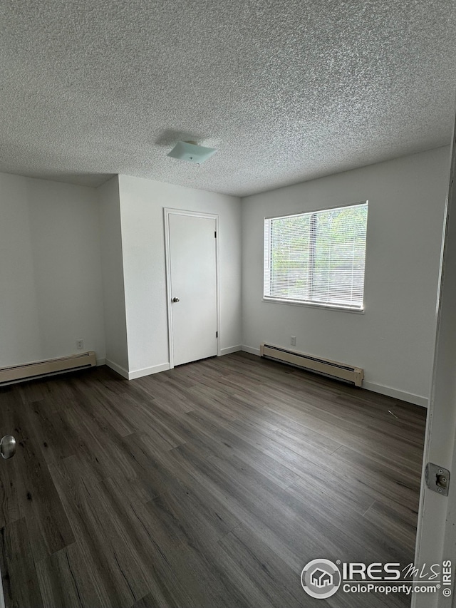 3328 Mcconnell Dr, Laporte, CO 80535 - unfurnished bedroom featuring a baseboard radiator, dark wood-style flooring, and baseboards