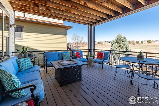 wooden terrace with outdoor dining area and an outdoor living space with a fire pit