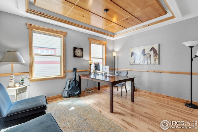 home office featuring baseboards, wood finished floors, and a tray ceiling