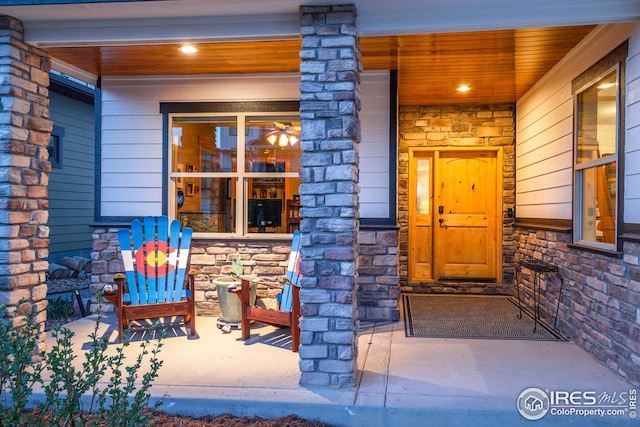 property entrance with covered porch and stone siding