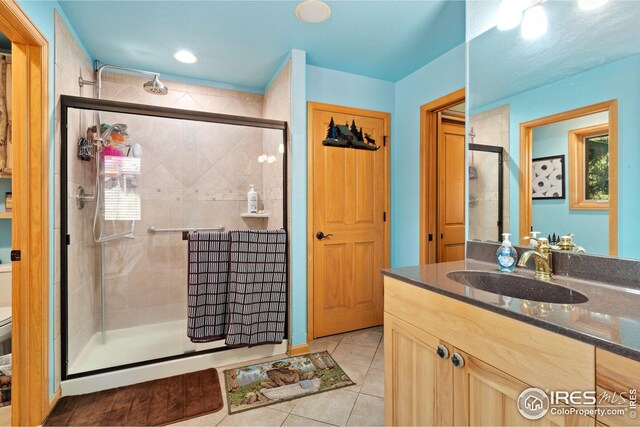 full bath featuring toilet, a stall shower, tile patterned flooring, and vanity