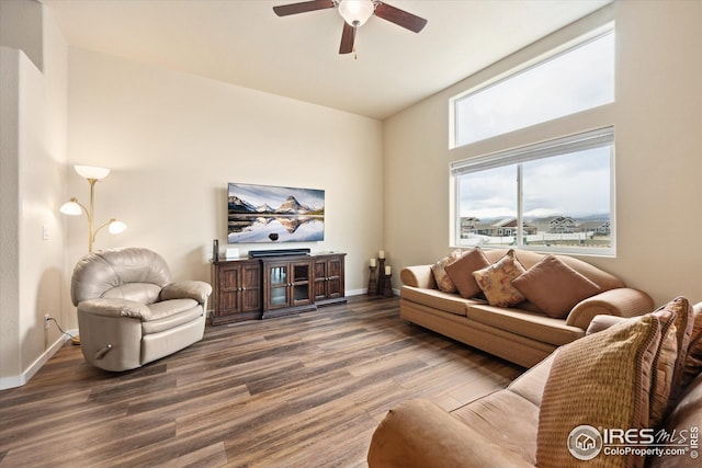 living room with a ceiling fan, baseboards, and wood finished floors