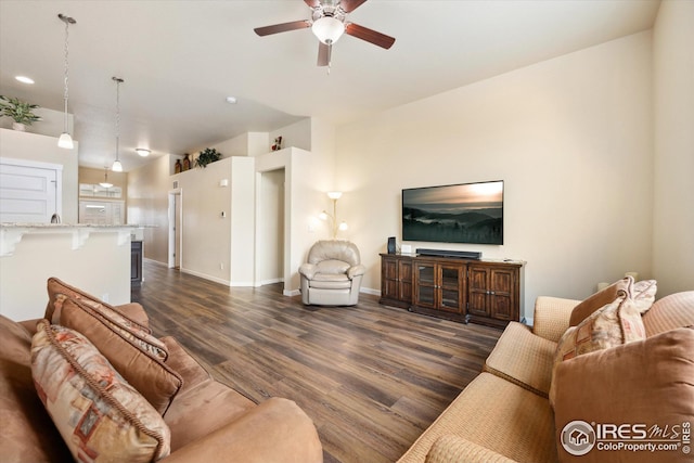 living area with baseboards, ceiling fan, and dark wood-type flooring