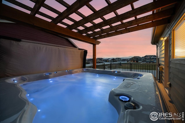view of swimming pool with a residential view, fence, and a hot tub