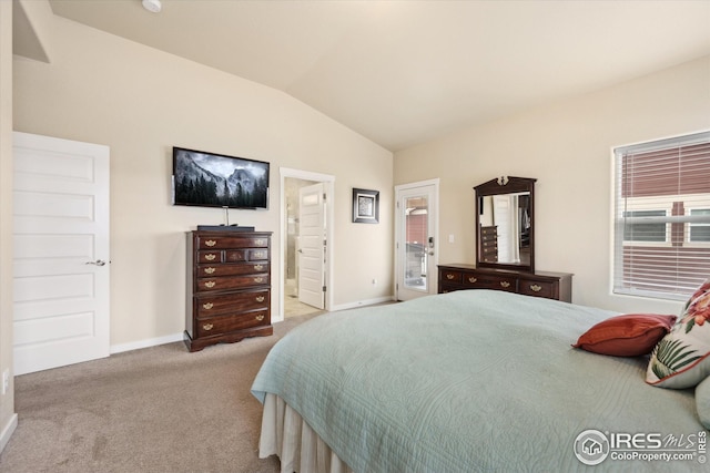 carpeted bedroom with ensuite bathroom, baseboards, and vaulted ceiling