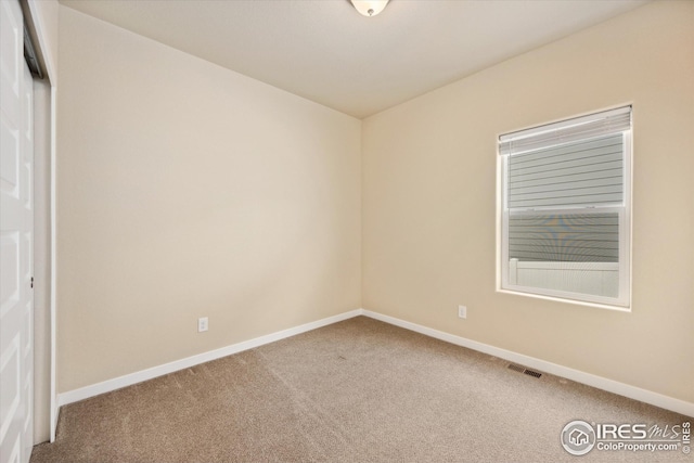 carpeted spare room with baseboards and visible vents