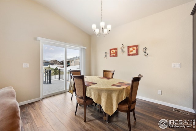 dining room featuring lofted ceiling, baseboards, visible vents, a notable chandelier, and wood finished floors
