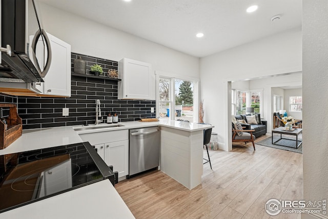 219 N Washington Ave, Loveland, CO 80537 - kitchen with white cabinets, a sink, light wood-style floors, stainless steel appliances, and recessed lighting